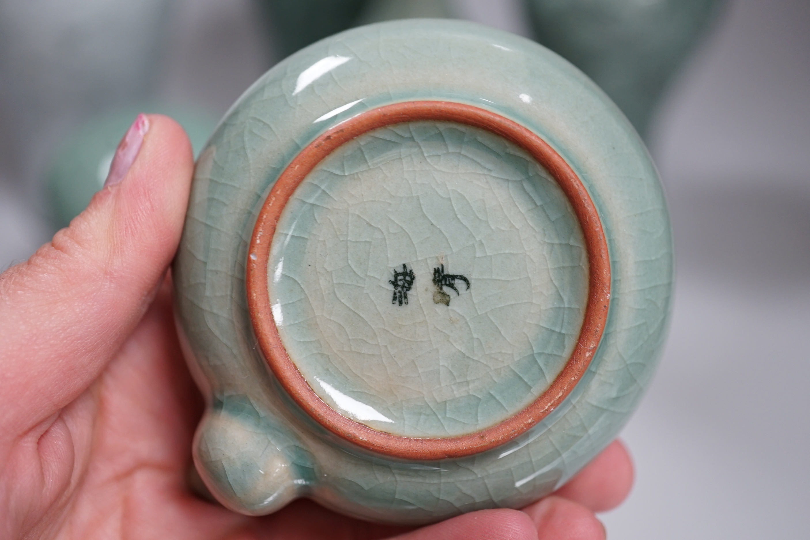 Seven pieces of Korean celadon glazed ceramics including four vases decorated with cranes amongst clouds, the largest 22cm high